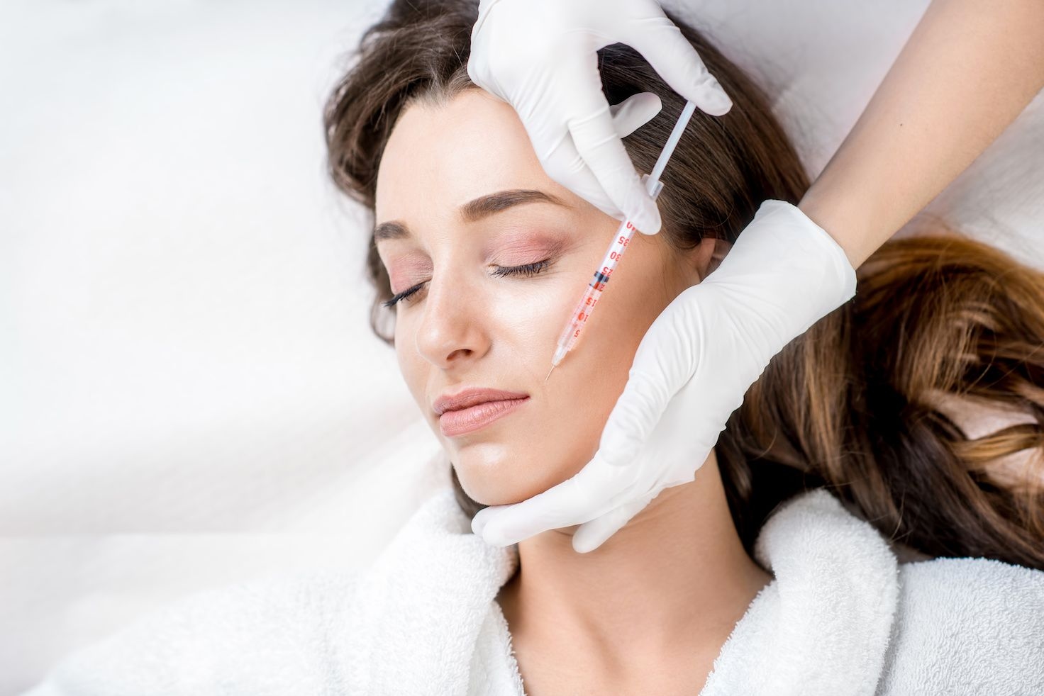 Woman receiving anti-wrinkle injection eye closed